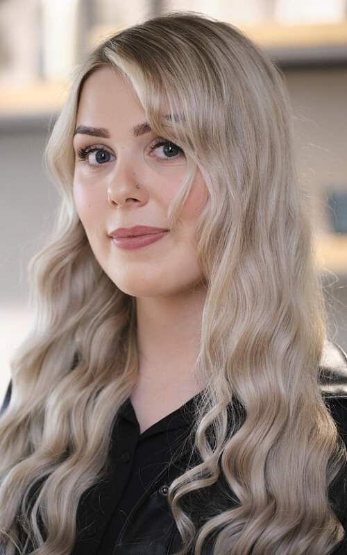 Friseurin S. Franke Porträt von S. Franke, eine Friseurin mit langen, grauen Haaren, in einem modernen Friseursalon.